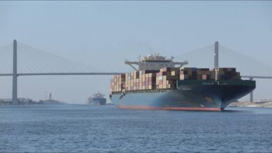 A large MSC container ship navigates a canal, symbolizing record transits and global shipping.