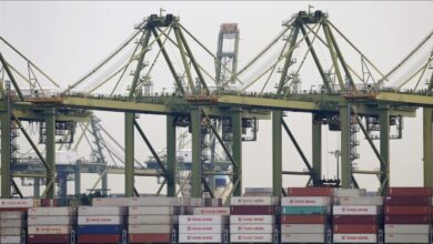 A large container ship docked at a busy port, representing the maritime and bunker industries.
