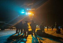 U.S. Coast Guard cutter patrols near a large tanker on the open ocean.