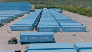 A large Maersk container ship sails on the sea, representing global shipping routes.