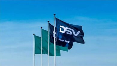 A large DSV logistics warehouse with stacked goods and a forklift, illustrating global supply chains.