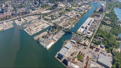 Aerial view of the Port of Toronto with cargo ships, containers, and the city skyline.