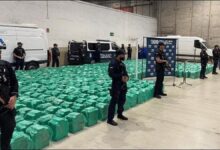 Spanish police officers display large bales of seized cocaine after a maritime drug bust.