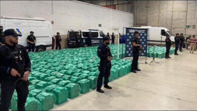 Spanish police officers display large bales of seized cocaine after a maritime drug bust.