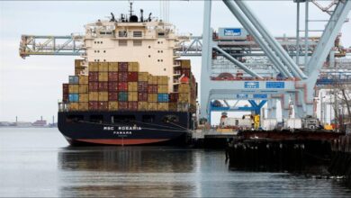 Large cargo ship sailing near an industrial port, relevant for marine fuel and decarbonization.