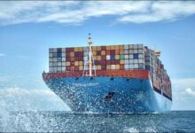 A large blue Maersk container ship loaded with cargo sails on the open ocean.