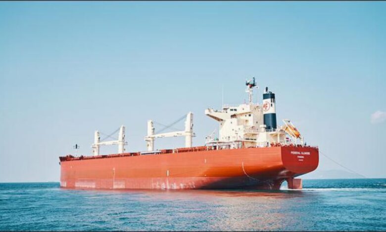 A large cargo ship, likely operated by Marubeni Group, sails on the open ocean.