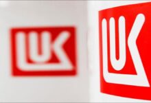 An industrial oil refinery complex with tanks and pipes, representing global energy assets.