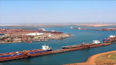 A large container ship sails on calm seas, boosting maritime trade and port capacity.