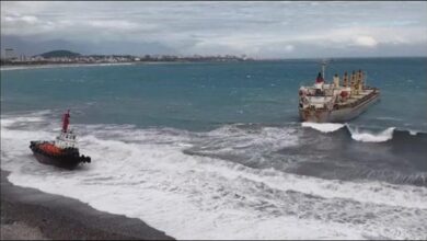 A grounded bulker and a tug boat in rough waters off Taiwan during a maritime rescue.