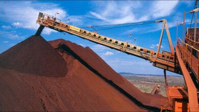 Rio Tinto's Pilbara iron ore mine with haul trucks and a train.
