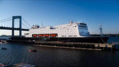 A large, modern tanker vessel sails across calm ocean waters.