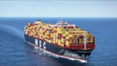 A large MSC container ship sails on the open ocean.