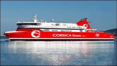 A modern white and blue E-Flexer ferry, likely A Nepita, sails on calm water.