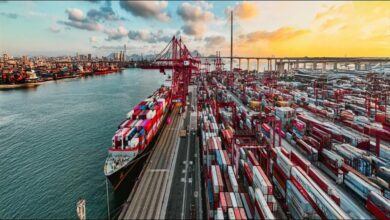 Container ships loading at a modern, busy port, symbolizing global trade and logistics in Asia.
