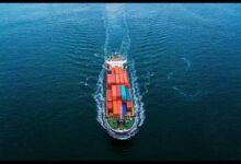 A large MSC container ship sails on the ocean under a partly cloudy sky.