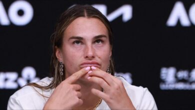 Aryna Sabalenka plays tennis on a blue court during the Australian Open.