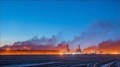 Industrial steel complex with towering structures and emissions, representing steel production.