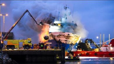 A large maritime vessel uses a fire monitor to spray water during a firefighting exercise.