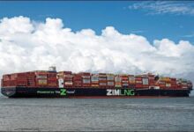 A large Zim container ship, laden with cargo, sails on the ocean.
