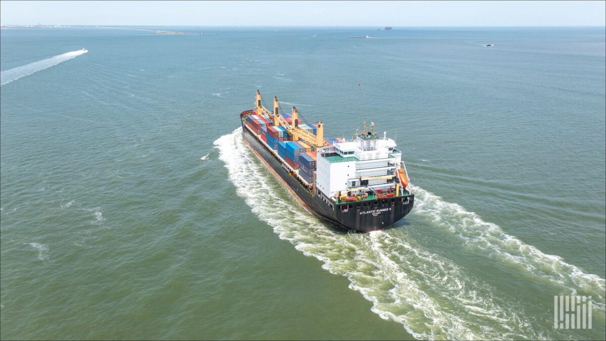 A large cargo ship takes on fuel from a bunker vessel at sea.