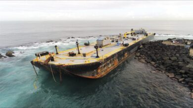 Salvage crews remove fuel from the grounded Defiant barge near San Juan Harbor, Puerto Rico.
