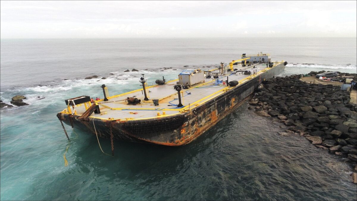 Salvage crews remove fuel from the grounded Defiant barge near San Juan Harbor, Puerto Rico.