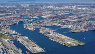 Panoramic view of a bustling Port of Los Angeles at sunset, with container ships and gantry cranes.