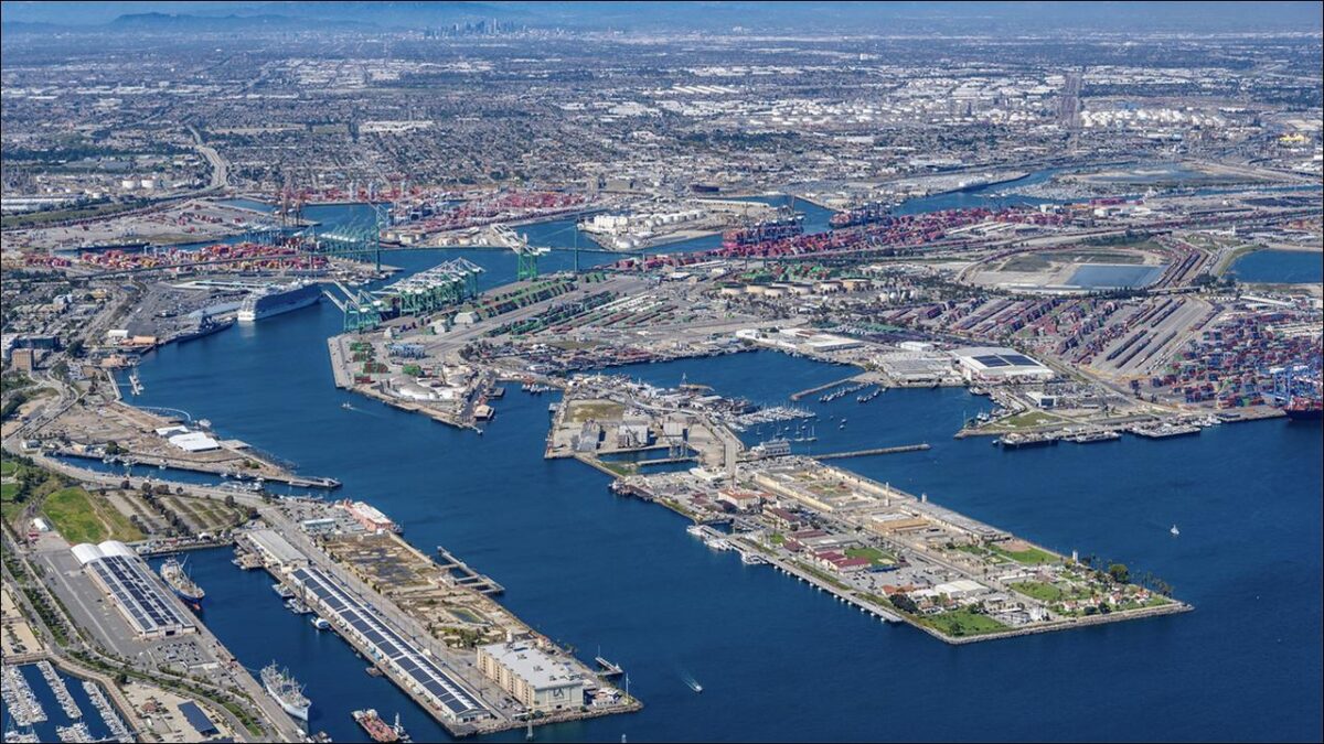 Panoramic view of a bustling Port of Los Angeles at sunset, with container ships and gantry cranes.