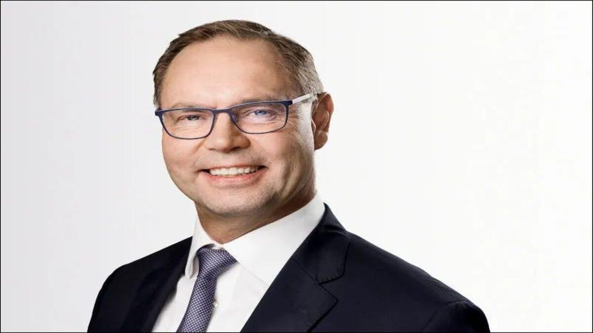 A container ship being serviced by cranes at a busy port, symbolizing logistics and infrastructure.