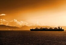 A large LNG carrier ship with distinctive spherical tanks sailing on open water.