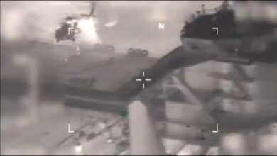 U.S. military personnel board the Sophia tanker at sea.