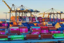 An Evergreen container ship with stacked containers docked at a bustling international port.