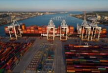 A large Hapag-Lloyd container ship carrying cargo sails across the ocean.