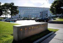 A large blue Maersk container ship sails on the ocean.