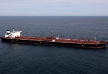 A large oil tanker sails on the sea, representing global maritime shipping.