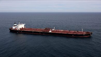 A large oil tanker sails on the sea, representing global maritime shipping.