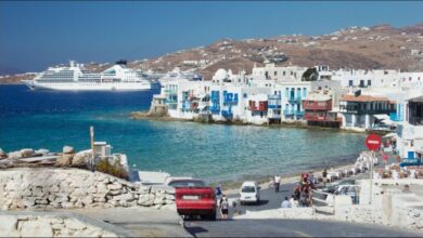 A large cruise ship at anchor off Mykonos, Greece, supporting the tourism industry.