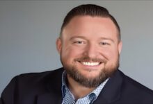 A large container ship loaded with cargo sails, symbolizing international import trade and tariffs.