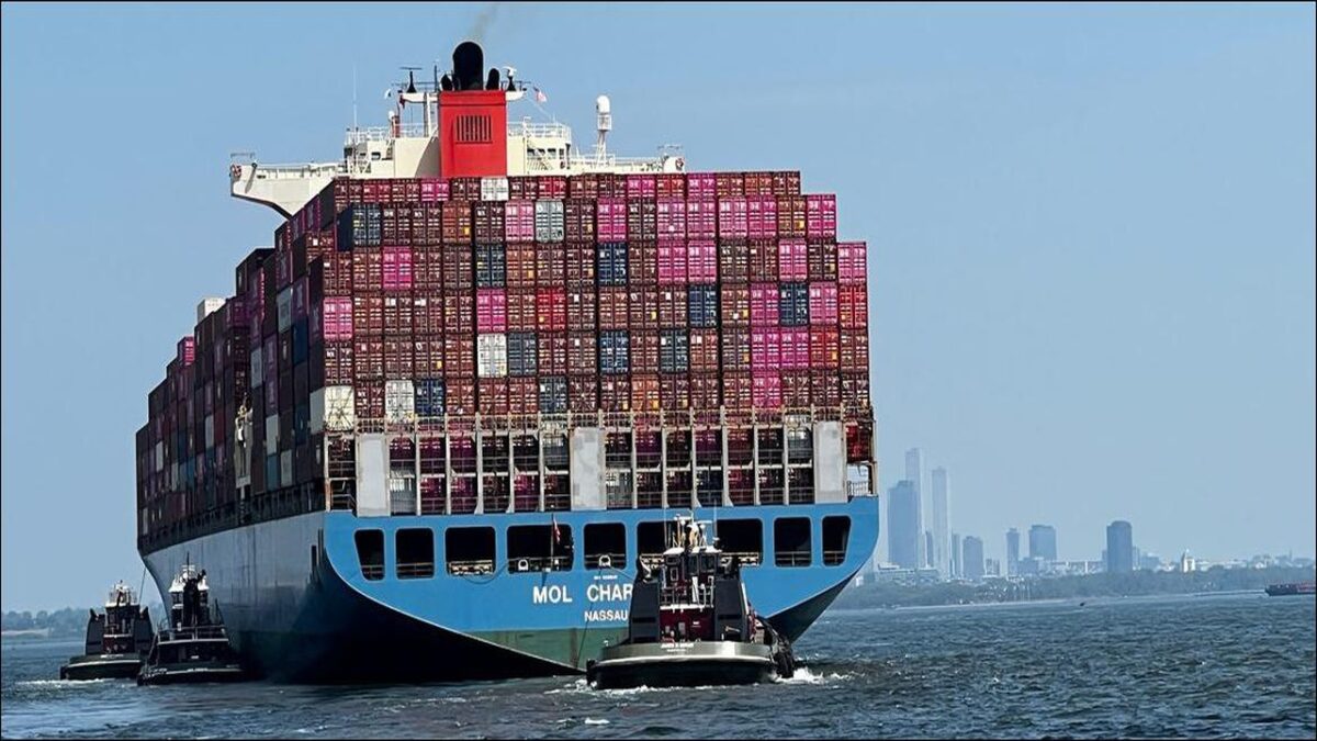 A large container ship transports goods across the ocean, representing global trade.