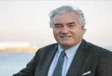 An LPG carrier ship with distinctive dome-shaped tanks sails on the ocean.