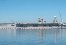 The USS Truxton, a grey naval destroyer, sails on the ocean.