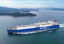 A modern NYK dual-fuel LNG carrier sailing on calm waters.