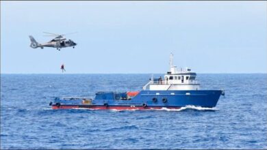 French Navy personnel inspect large drug bales seized on a vessel at sea.