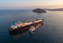 Large LNG carrier vessel with spherical tanks sailing on the open sea.
