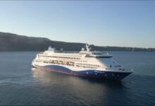 The Celestyal Discovery cruise ship sails on calm blue water.