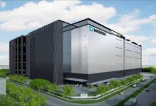 Maersk branded shipping containers stacked at a logistics hub in Singapore.