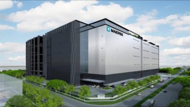 Maersk branded shipping containers stacked at a logistics hub in Singapore.