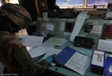 A large oil tanker at sea with a military helicopter overhead during a maritime interception.