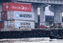 Maersk shipping containers stacked on a large cargo vessel.